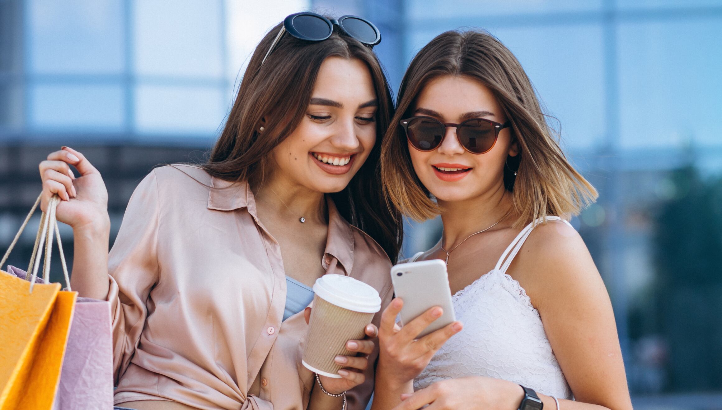 Dos mujeres revisando su teléfono celular mientras aprovechan las mejores ofertas del Black Friday (Foto: Freepik)