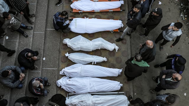 Los deudos permanecen junto a los cuerpos amortajados de familiares asesinados tras los ataques de Israel en Khan Yunis, en el sur de la Franja de Gaza, el 9 de diciembre de 2023. (Foto de AFP).