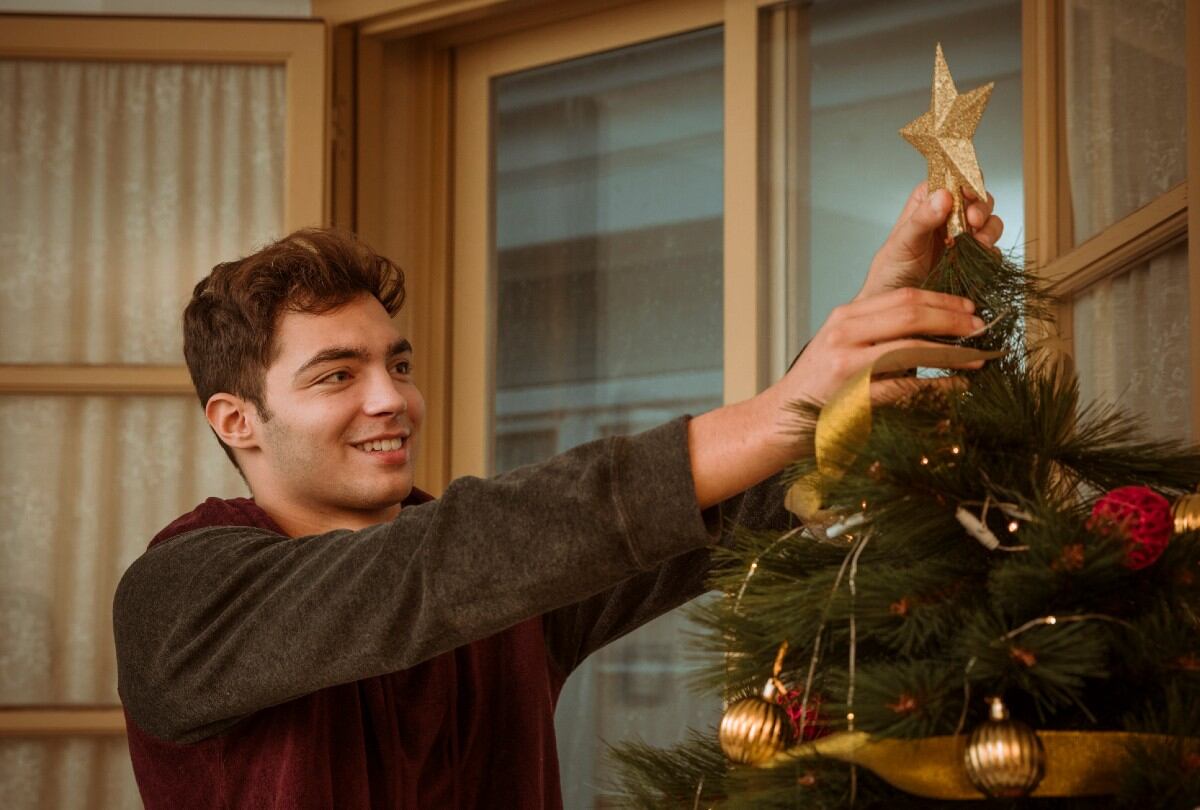 Joven decora el árbol de Navidad. (Foto: Freepik)