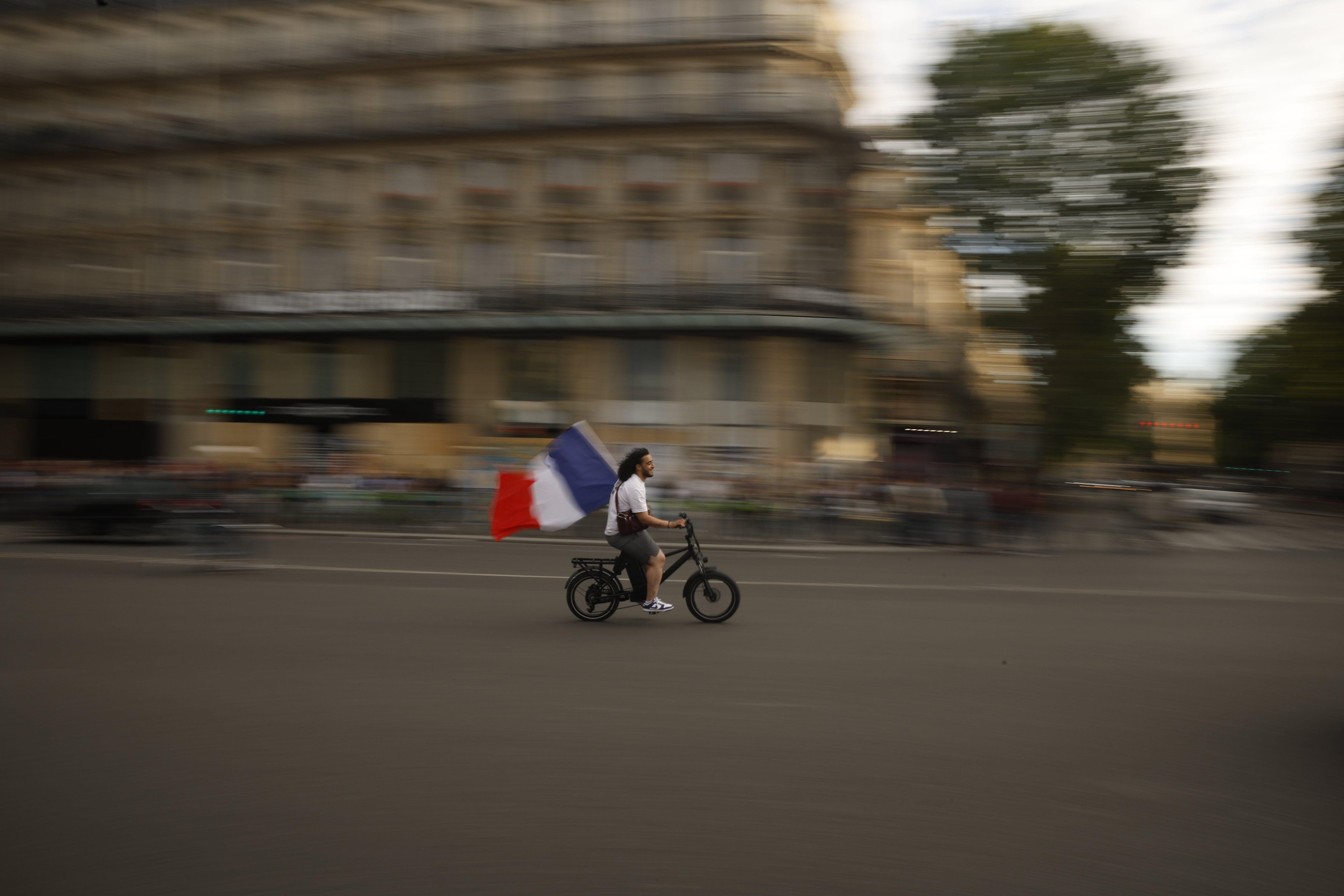 Un manifestante con la bandera francesa en bicicleta por las calles de París. (EPA).