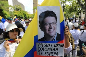 Una mujer sostiene una bandera nacional durante la llamada "Marcha Silenciosa" para mostrar apoyo a la salud del senador Miguel Uribe Turbay y pedir paz para el país en Medellín, Colombia, el 15 de junio de 2025. (Foto de JAIME SALDARRIAGA / AFP)