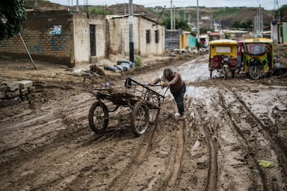 Un residente empuja su carreta a través del lodo tras las inundaciones provocadas por las lluvias en la provincia de Paita, en Piura, al norte del Perú, el 24 de marzo de 2017, durante el fenómeno climático El Niño. (Foto de Ernesto BENAVIDES / AFP).