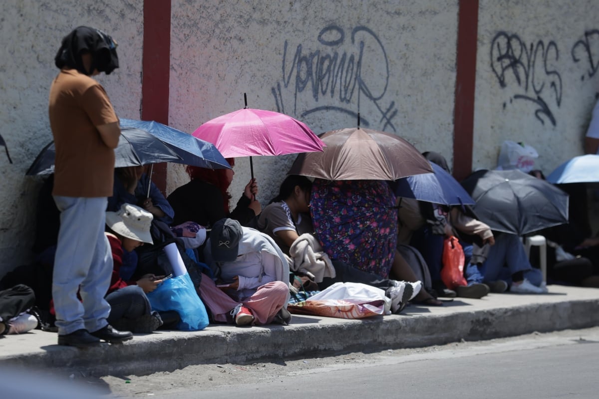 Integrantes de ARMY permanecen en la vía pública con sombrillas y otros objetos mientras esperan el ingreso al recinto. (Foto: Hugo Pérez /@photo.gec)