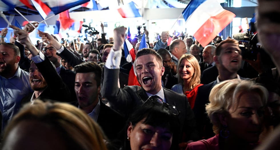 Los militantes celebran el anuncio de los resultados de la votación durante una reunión nocturna del partido de extrema derecha francés Agrupación Nacional. (Foto de JULIEN DE ROSA / AFP).