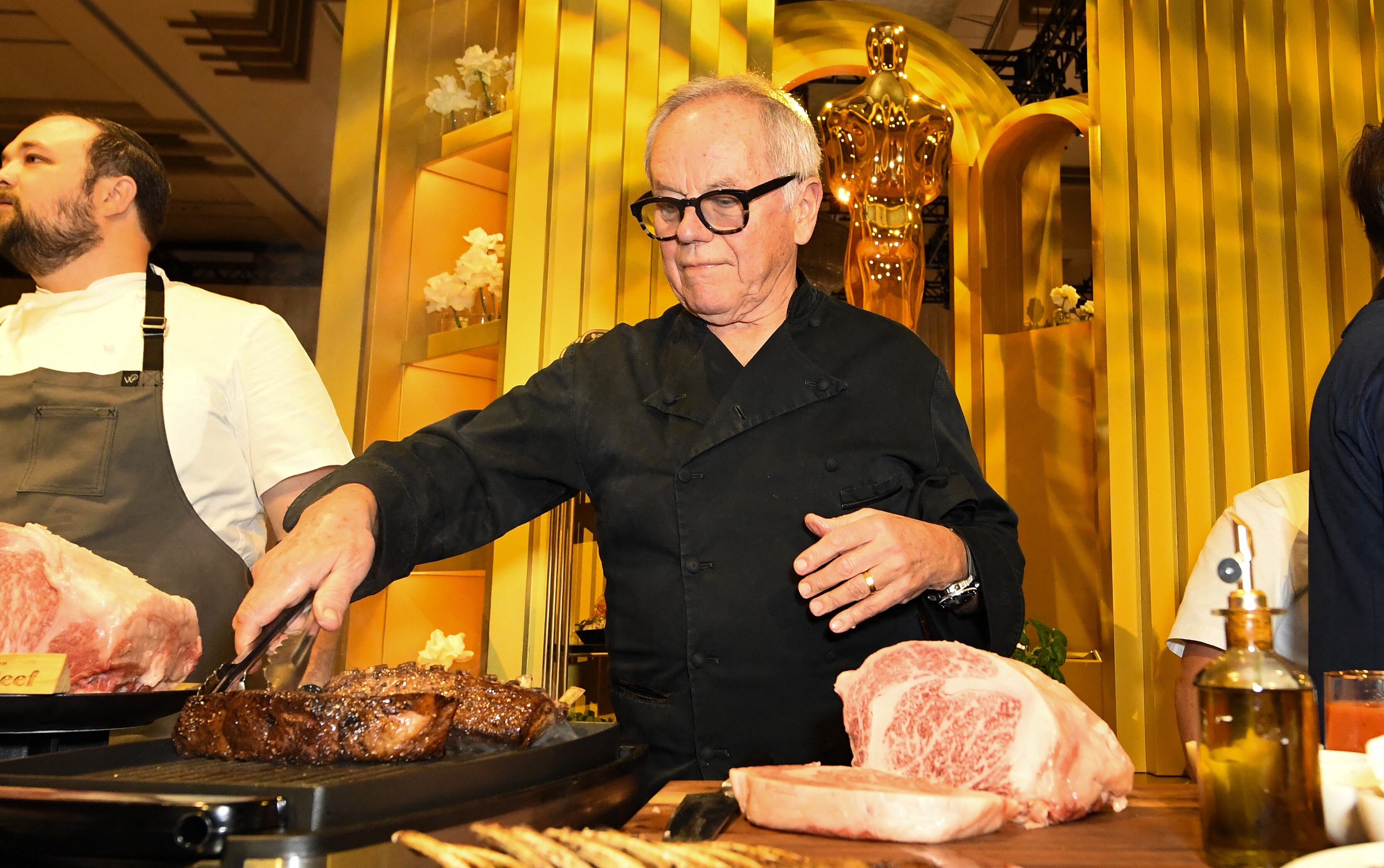 El chef austriaco Wolfgang Puck cocinando carne en la previa de la 96° edición de los Premios de la Academia (Foto: AFP)