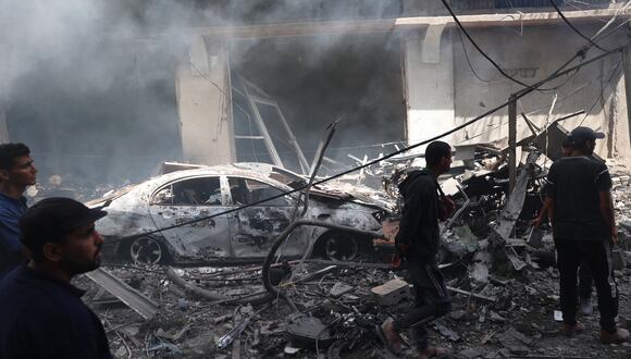 Hombres palestinos observan la destrucción tras las operaciones de las Fuerzas Especiales israelíes en el campamento de Nuseirat, en el centro de la Franja de Gaza, el 8 de junio de 2024, en medio del conflicto en curso entre Israel y el grupo militante palestino Hamas. (Foto de Eyad BABA / AFP)