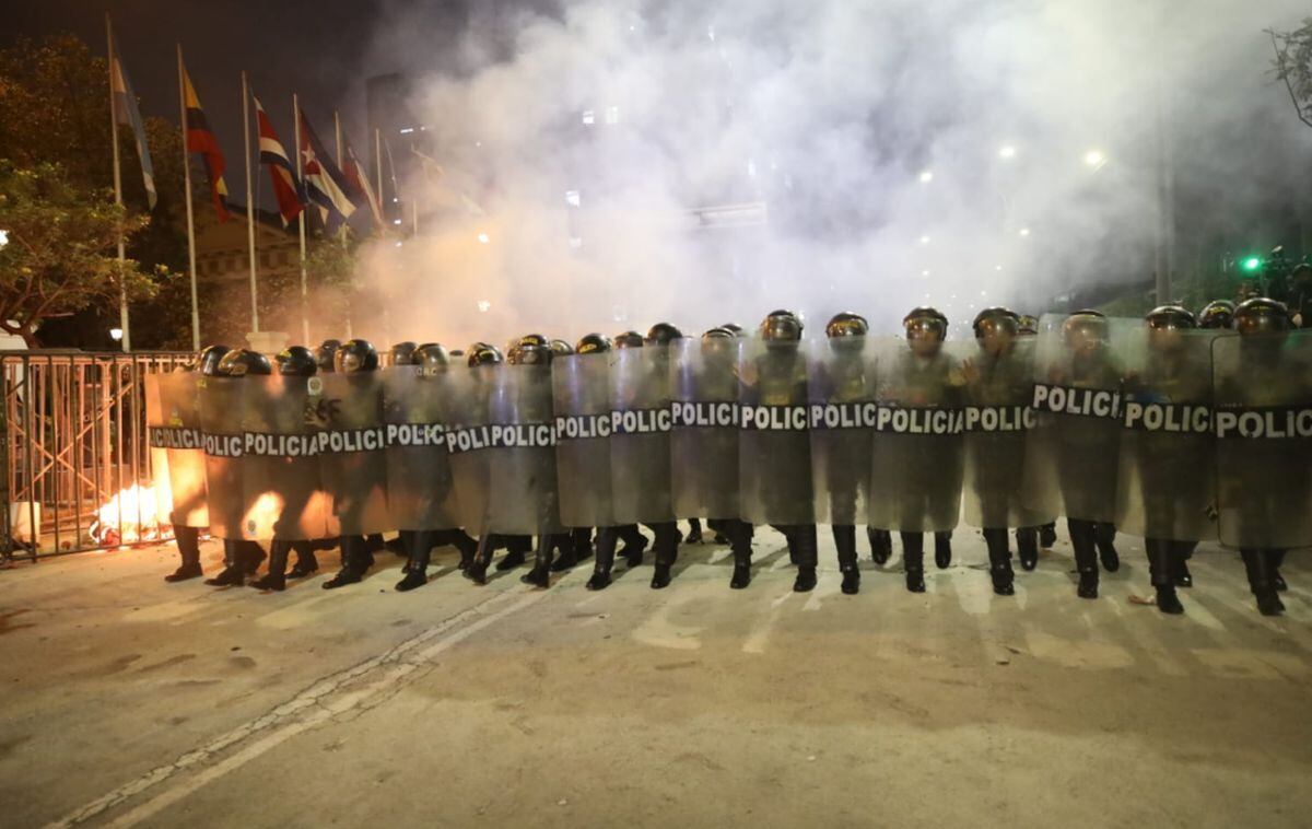 Policías se resguardan tras ser atacados por un grupo de personas que se encontraba entre los manifestantes | Diana Marcelo/ @photo.gec