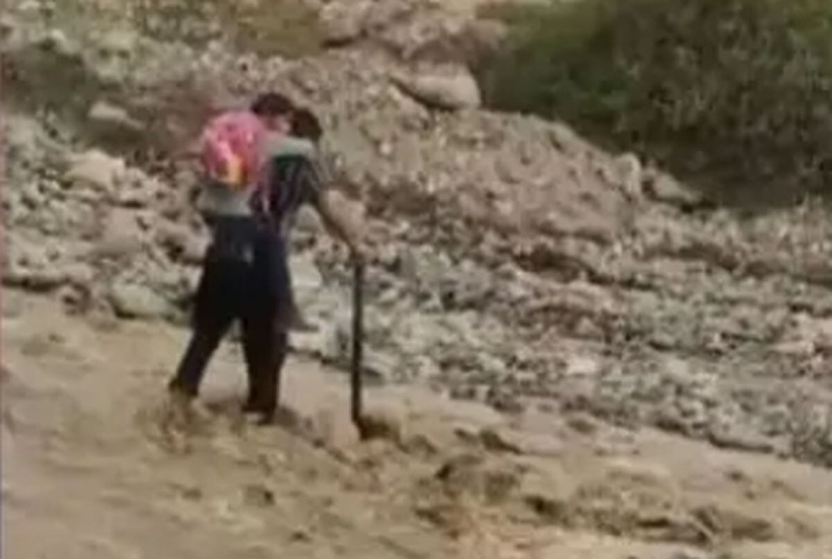 Docente carga a su alumna en la espalda para que pueda cruzar el río y así llegar a su centro educativo | Captura RPP Noticias