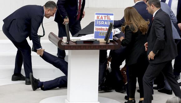 El diputado del Partido Felicity (Saadet), Hasan Bitmez, es atendido mientras yace en el suelo después de desplomarse mientras pronunciaba un discurso el 12 de diciembre de 2023. (Foto de Adem ALTAN / AFP).