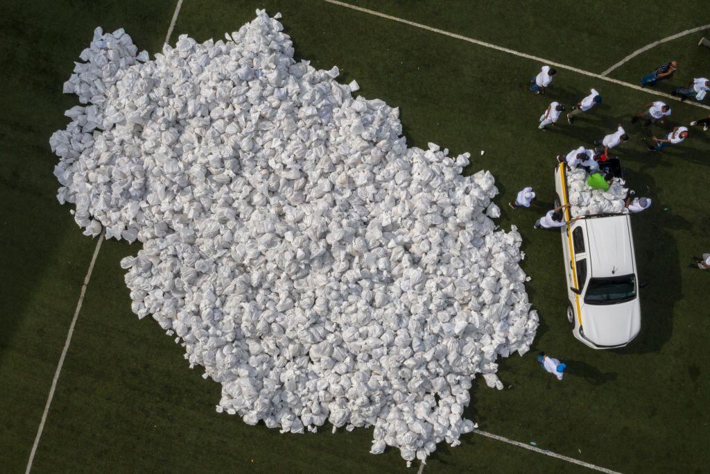 Voluntarios del "Plan de Solidaridad de Panamá" cargando bolsas con alimentos para familias de bajos ingresos.