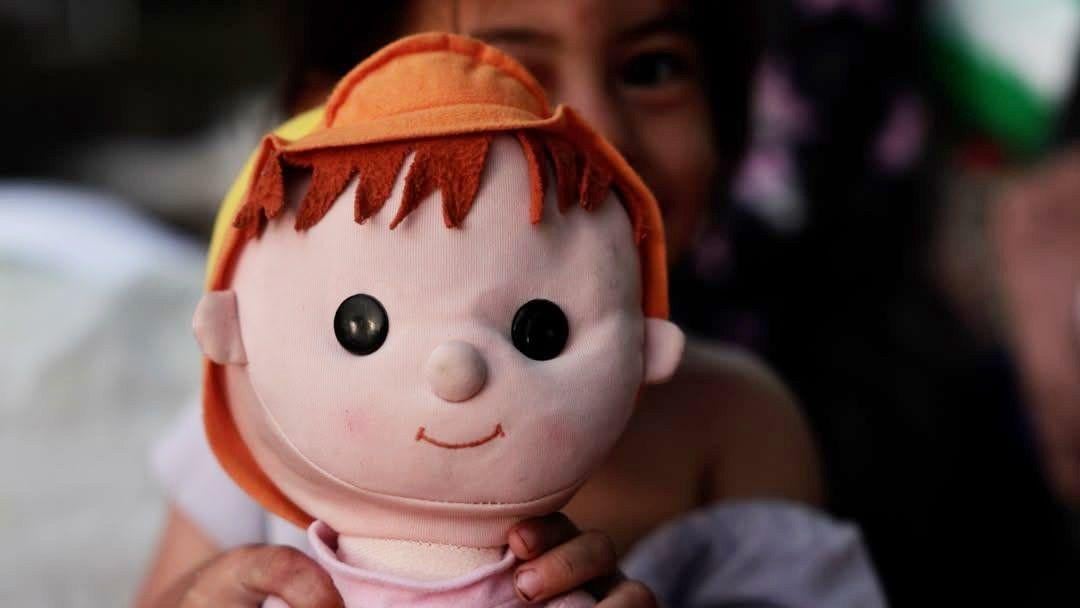 Una de las hijas de Milagros González jugando con una muñeca. (BBC Mundo).