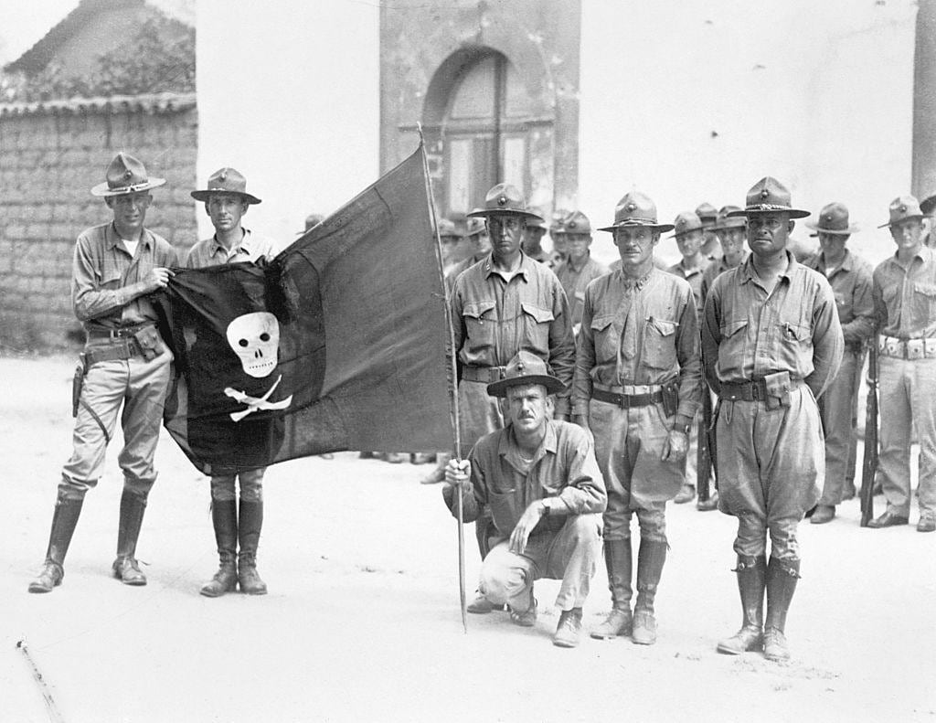Soldados estadounidenses exhiben una bandera capturada a la guerrilla de Sandino en 1932, poco antes de su retirada de Nicaragua. (GETTY IMAGES).