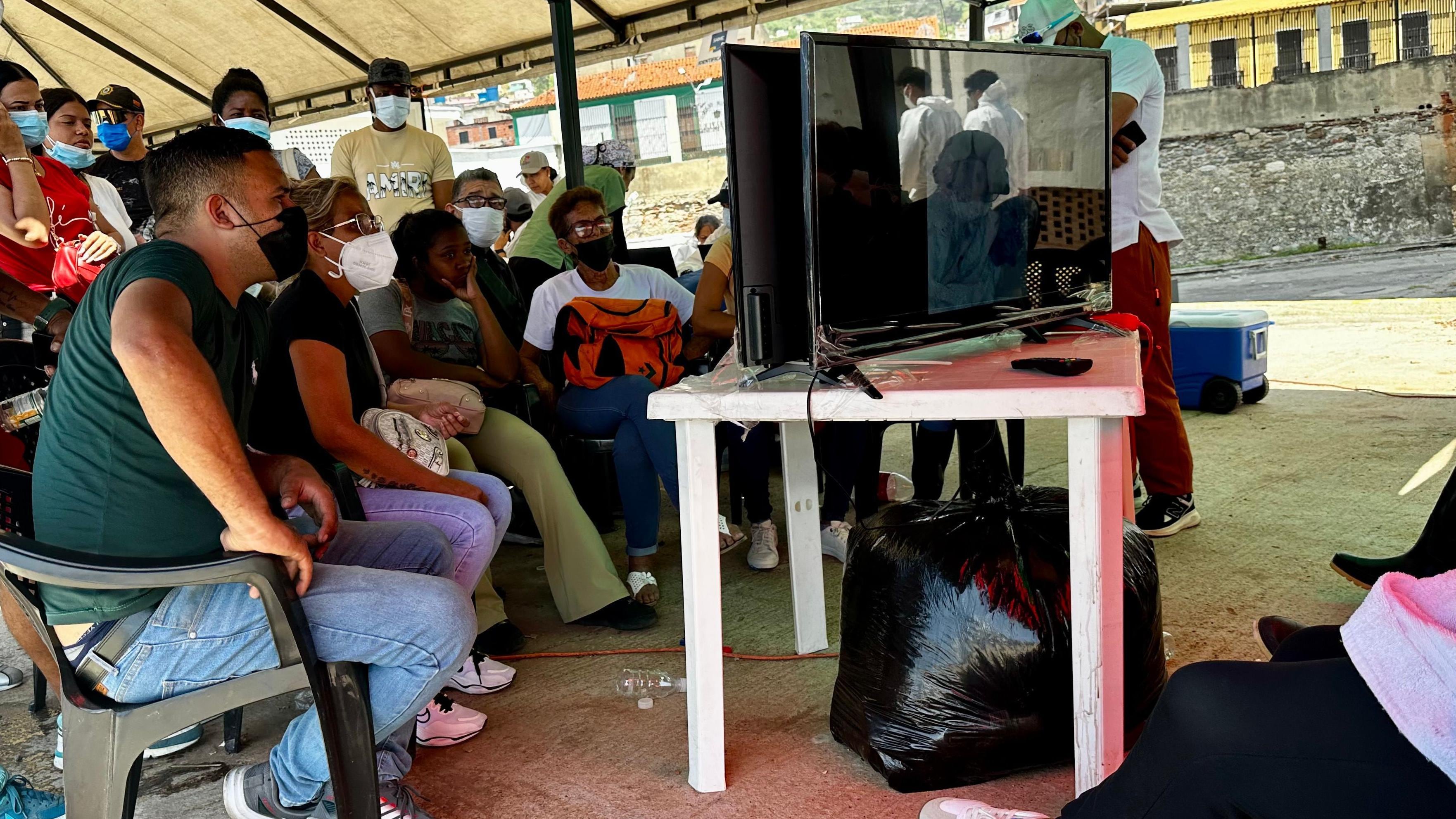 Las familias intentan identificar a sus seres queridos a través de imágenes que se deslizan en dos televisores. Buscan un tatuaje, una cicatriz, una prenda o cualquier señal que permita reconocerlos. Muchos de los cuerpos son ya irreconocibles. (BBC Mundo).