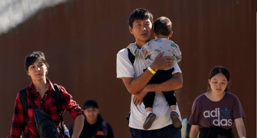 Migrantes caminan a lo largo del muro cerca de Jacumba, California, después de cruzar la frontera con México para buscar asilo en Estados Unidos. (Gregory Bull / AP).