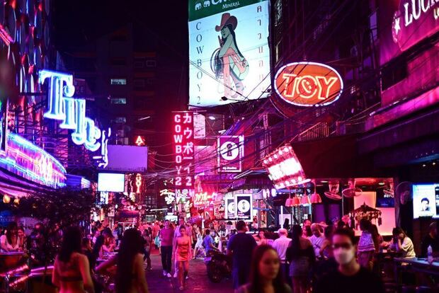 Visitantes caminando por la popular calle de entretenimiento nocturno conocida como Soi Cowboy en Bangkok. (GETTY IMAGES).