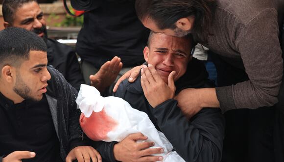 Un hombre llora durante el funeral de sus parientes de la familia Kalusa, que murieron en un ataque israelí en Khan Yunis, en el sur de la Franja de Gaza, el 22 de noviembre de 2023. (Foto de MAHMUD HAMS / AFP).