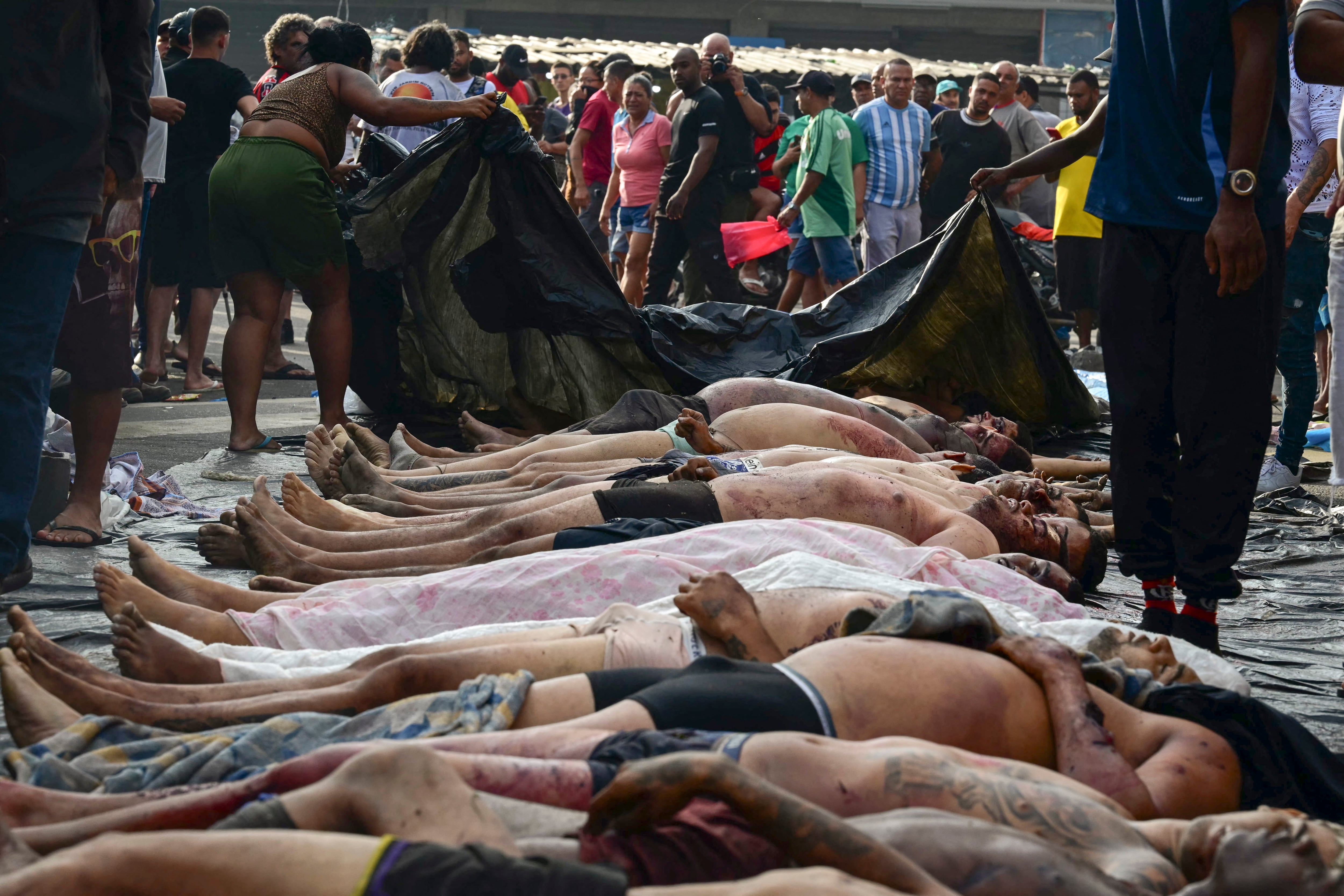 Cuerpos alineados en la plaza São Lucas de la favela Vila Cruzeiro, en el complejo Penha, en Río de Janeiro, Brasil, el 29 de octubre de 2025, tras la Operación Contención. (Foto de Pablo PORCIUNCULA / AFP).