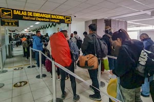 Esta imagen distribuida por el Ministerio de Transporte de Perú muestra a los turistas esperando en fila para abordar un avión en el Aeropuerto Internacional Alejandro Velasco Astete en Cusco, Perú