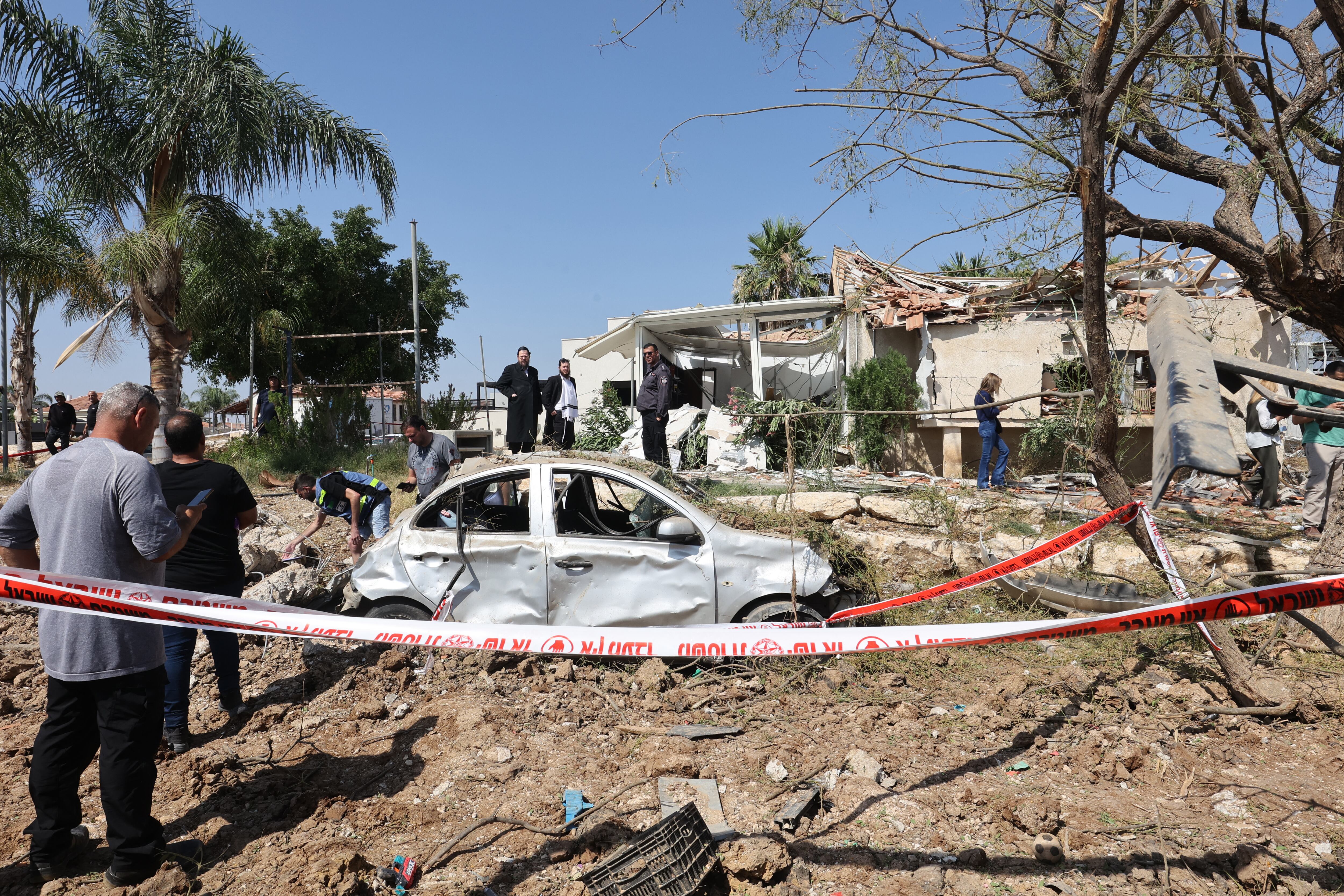 Personas revisan los daños en el lugar de un ataque con misiles iraníes en el moshav Zavdiel, cerca de Kiryat Gat, en el sur de Israel, el 16 de junio de 2025. (Foto de GIL COHEN-MAGEN / AFP)