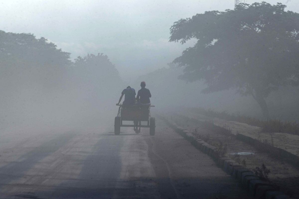 Dos personas transitan una carretera llena de cenizas, en la comunidad La Grecia, el 6 de julio de 2023, tras la explosión del volcán San Cristóbal este miércoles en la ciudad de Chinandega, Nicaragua. (Foto de Jorge Torres / EFE)