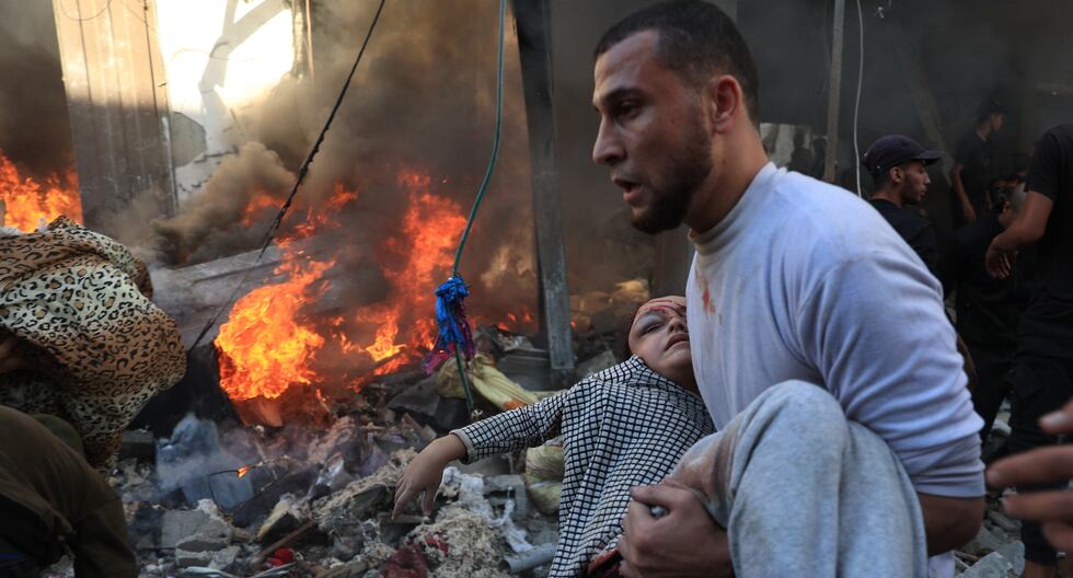 Un hombre evacua a una niña herida después del bombardeo de Israel en Rafah, en el sur de la Franja de Gaza, el 17 de noviembre de 2023. (Foto de SAID KHATIB / AFP).