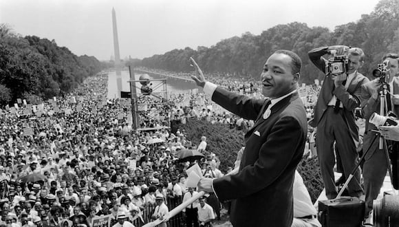 El líder de los derechos civiles de EE. UU., Martin Luther King (centro), saluda a sus seguidores el 28 de agosto de 1963 en el Mall de Washington DC. (Foto de AFP)