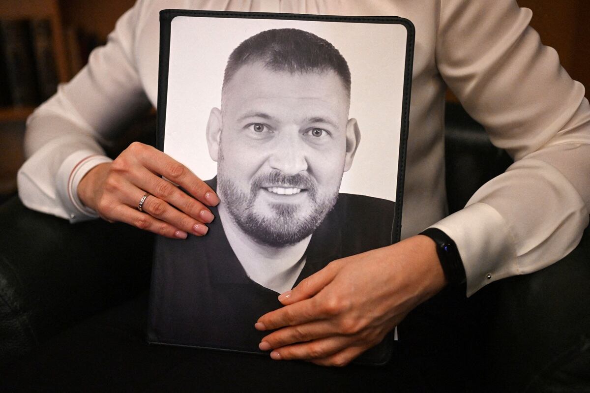 La líder opositora bielorrusa exiliada Svetlana Tikhanovskaya sostiene una carpeta con una foto de su marido encarcelado Sergei Tikhanovsky durante una entrevista en Varsovia. (Foto de Sergei GAPON / AFP)