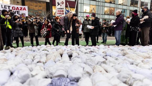 Gente coloca fardos destinados a representar los cuerpos de niños durante una vigilia por los muertos en el conflicto en curso entre Israel y Hamás en Nueva York, Nueva York, EE. UU., el 28 de diciembre de 2023. (Foto de EFE/EPA/JUSTIN LANE)