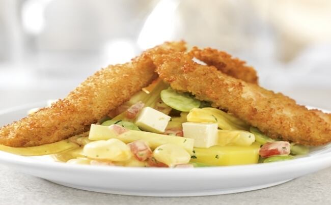 Una fresca ensalada de papas, queso, choclo y tomates en salsa de mayonesa le dan vida y sabor a los trozos crocantes de pollo cubiertos con quinua.