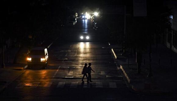 Personas cruzan la calle durante un apagón. (Foto de EFE)