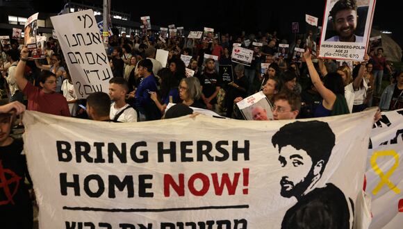 Familiares y simpatizantes levantan pancartas y despliegan una pancarta con retratos del rehén israelí Hersh Goldberg-Polin, de 23 años, y otros rehenes retenidos en Gaza desde los ataques del 7 de octubre por parte de Hamás en el sur de Israel. (Foto de AHMAD GHARABLI / AFP)