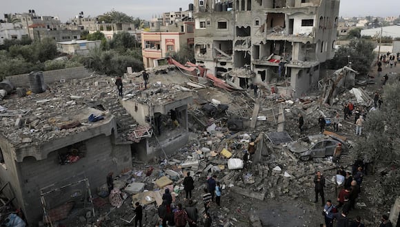 Palestinos buscan cadáveres y supervivientes entre los escombros de la casa destruida de la familia Manasra tras un ataque aéreo israelí en el sur de la Franja de Gaza, el 25 de diciembre de 2023. EFE/EPA/MOHAMMED SABLE
