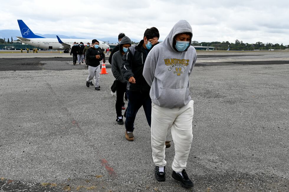 Migrantes guatemaltecos deportados de Estados Unidos caminan por la pista del aeropuerto a su llegada a la Base de la Fuerza Aérea en la Ciudad de Guatemala el 27 de enero de 2023. (Foto de Johan ORDÓNEZ/AFP).