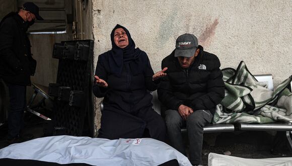 Los palestinos lloran después de identificar los cuerpos de sus familiares muertos en el bombardeo israelí nocturno en el sur de la Franja de Gaza, en el hospital Al-Najjar en Rafah, el 10 de febrero de 2024. (Foto de SAID KHATIB / AFP)