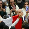 El papa León XIV reacciona ante los fieles que lo aclaman con una bandera peruana cuando sale de su audiencia general semanal en el Aula Pablo VI del Vaticano, el 14 de enero de 2026. (Andreas SOLARO / AFP)