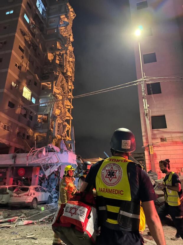 Integrantes de equipos de emergencia, bomberos y policía trabajan en el área donde un proyectil iraní impactó provocando el derrumbe de un edificio en Tel Aviv. (EFE/ Magen David Adom).