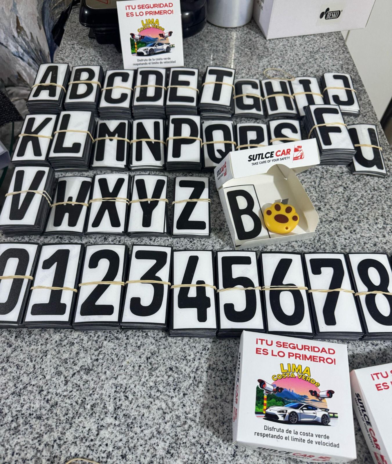 En las imágenes se muestra una mesa llena de adhesivos de todas las letras (de la A hasta la Z) y números (del 0 al 9).