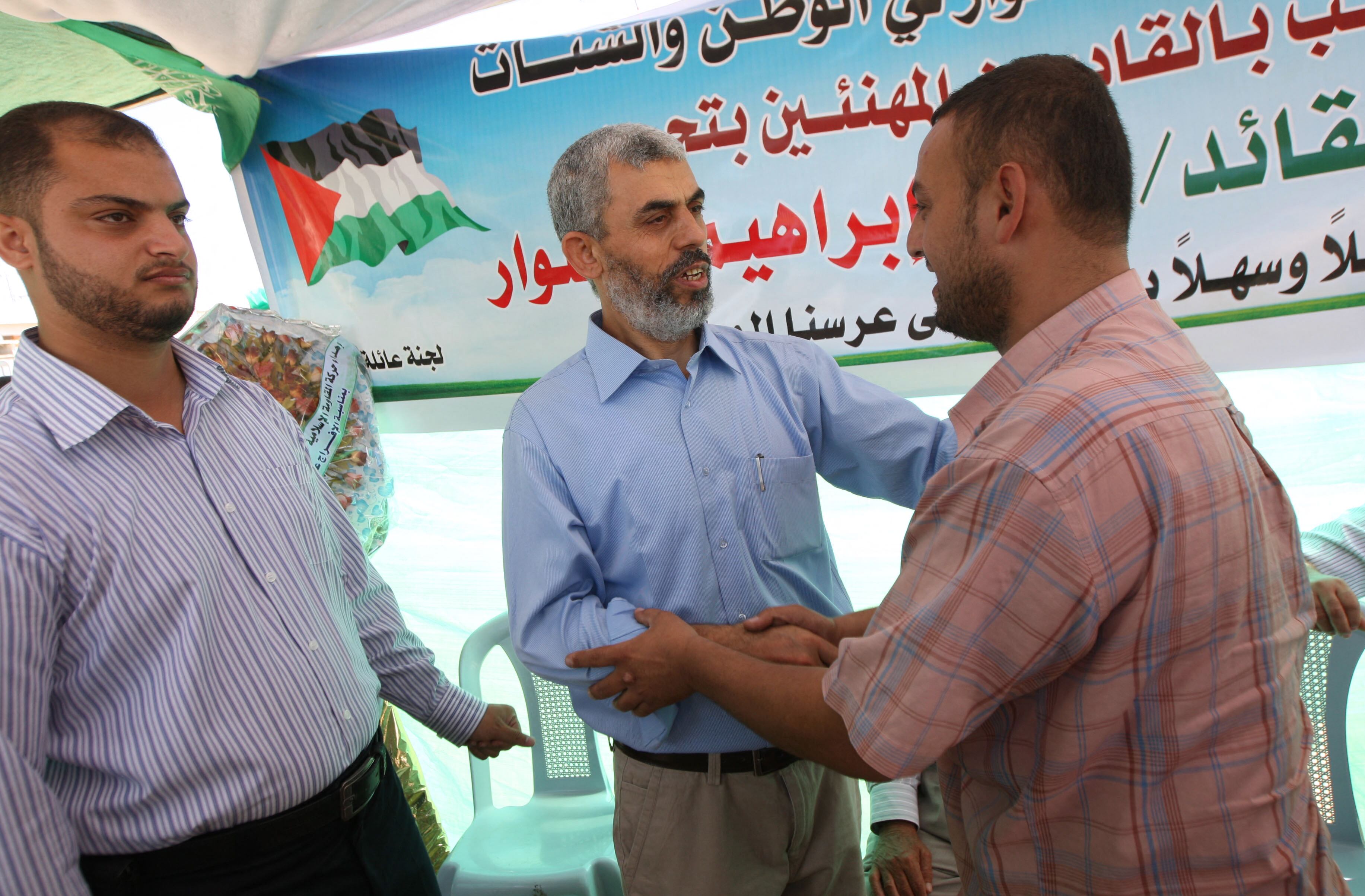 Yahya Sinwar (centro) saluda a sus partidarios tras su liberación de una cárcel israelí, el 19 de octubre de 2011. (Foto de SAID KHATIB / AFP).