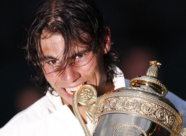 Rafael Nadal muerde su trofeo después de derrotar al suizo Roger Federer durante su último partido de tenis del campeonato de Wimbledon 2008. (Foto:AFP)