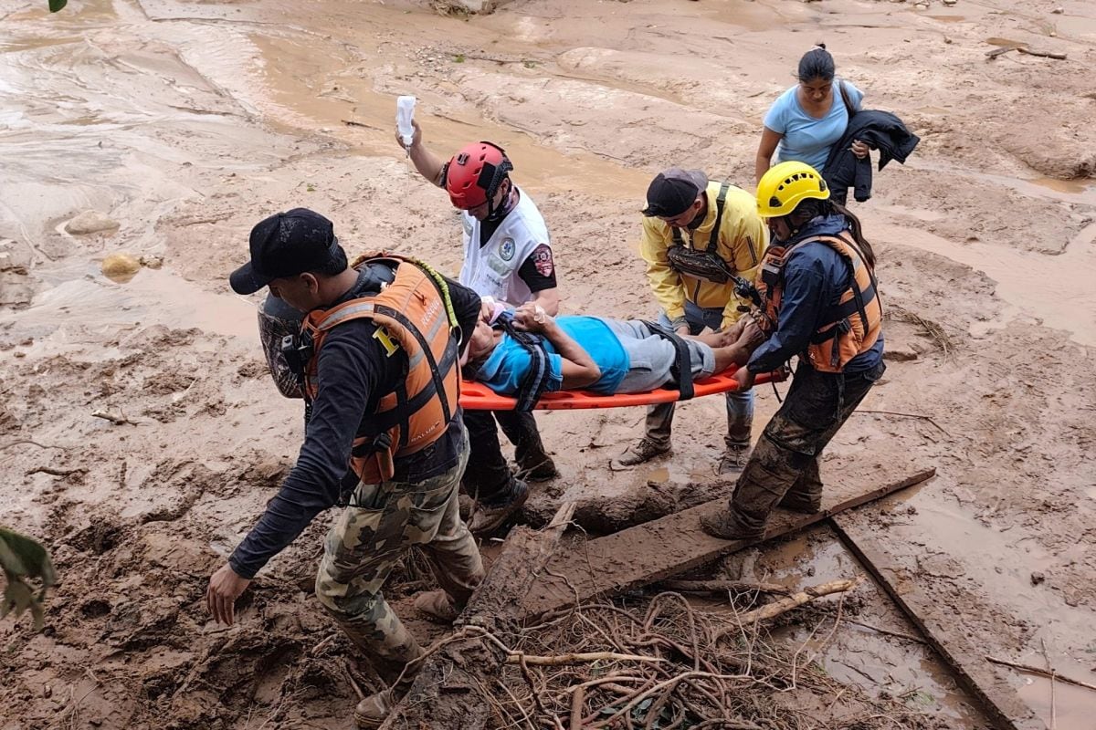 Personal de salud y equipos de rescate asisten a una persona afectada tras el desbordamiento de un río este sábado, en El Torno (Bolivia). Foto: EFE/Juan Carlos Torrejón