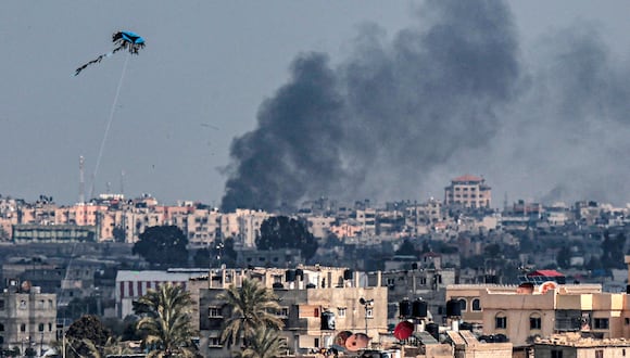 Se vuela una cometa en Rafah mientras se eleva el humo tras el bombardeo israelí de Khan Yunis, en el sur de la Franja de Gaza, el 20 de febrero de 2024, en medio de continuas batallas entre Israel y el grupo militante palestino Hamás. (Foto de SAID KHATIB / AFP)