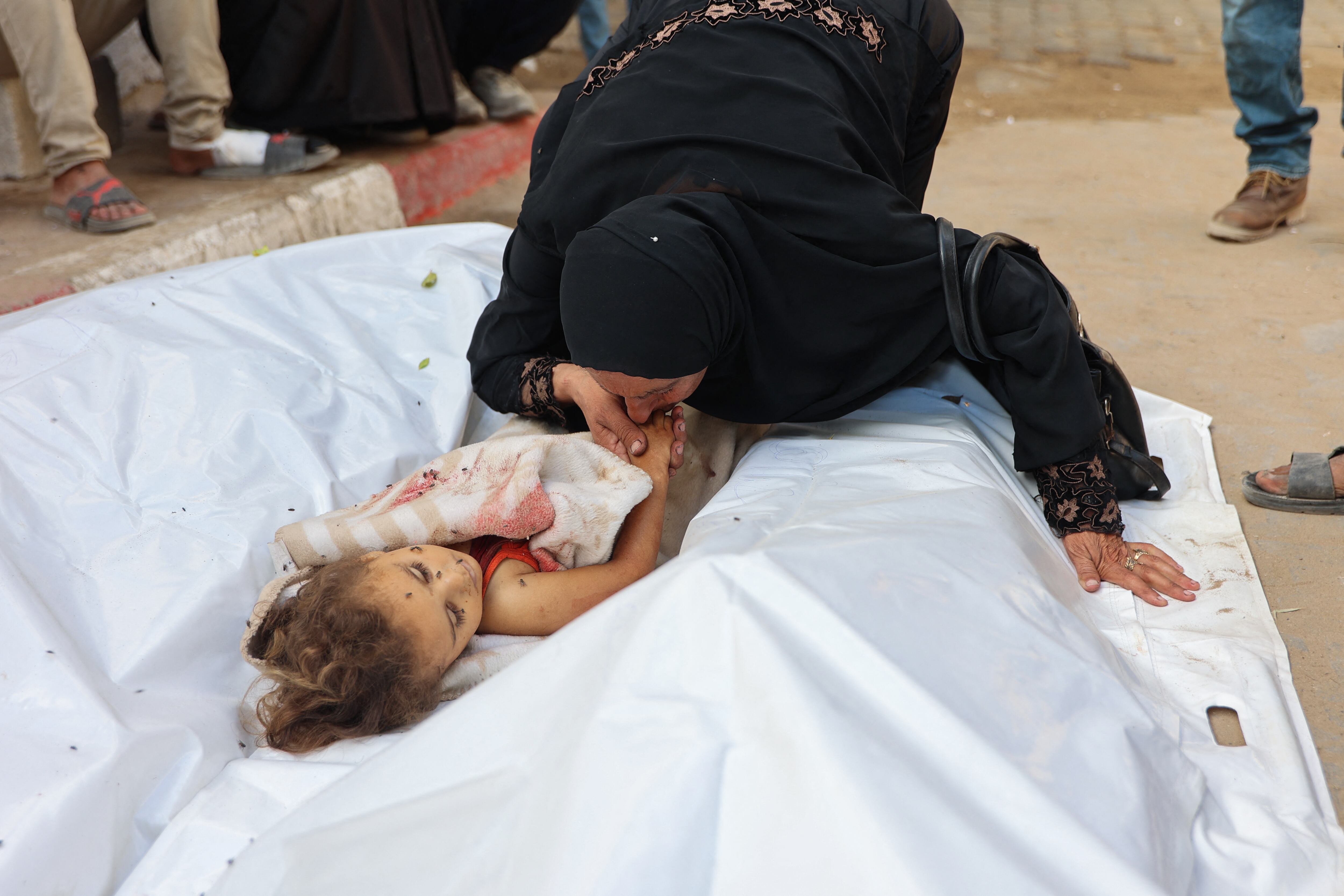 Rania Abu al-Qumbuz, de 50 años, llora junto al cuerpo de su nieta Rania Bakaroun, de 3 años, quien murió en un ataque de Israel contra su tienda de campaña en Gaza. (Foto de Omar AL-QATTAA / AFP).