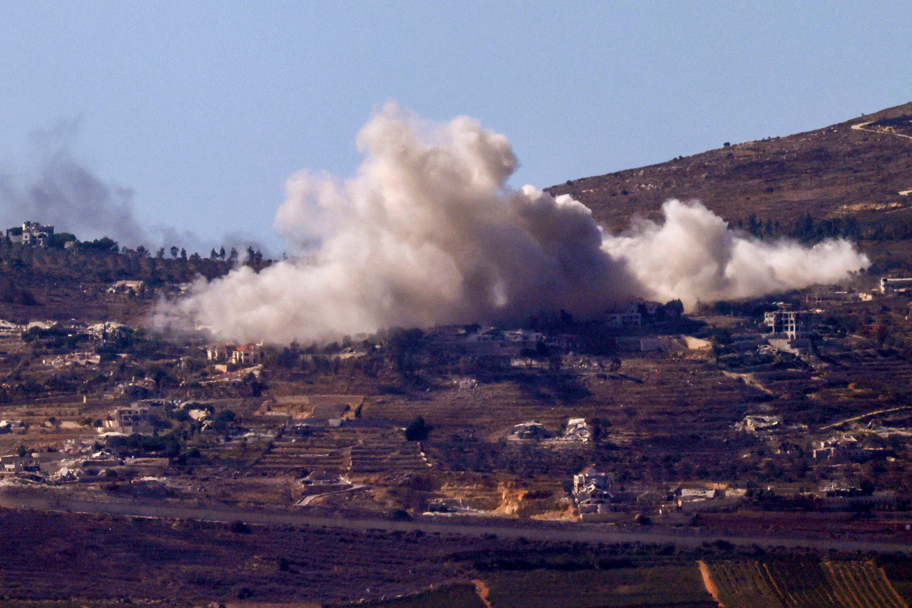 Una imagen tomada desde el norte de Israel, a lo largo de la frontera con el sur del Líbano, muestra una columna de humo sobre la aldea libanesa de Odaisseh durante un bombardeo israelí el 19 de octubre de 2024, en medio de la guerra en curso entre Israel y Hezbolá. (Foto de Jalaa MAREY / AFP)