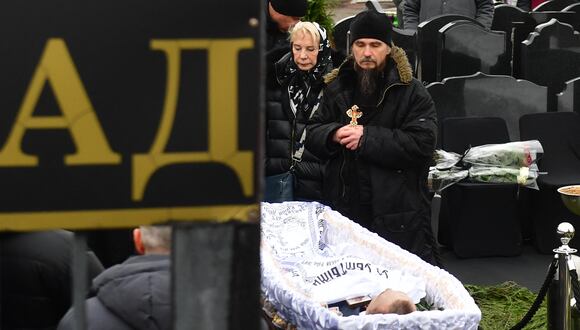 Un sacerdote ortodoxo está de luto junto al cuerpo del difunto líder de la oposición rusa Alexei Navalny durante una ceremonia fúnebre en el cementerio de Borisovo en el distrito moscovita de Maryino el 1 de marzo de 2024. (Foto de Olga MALTSEVA / AFP)