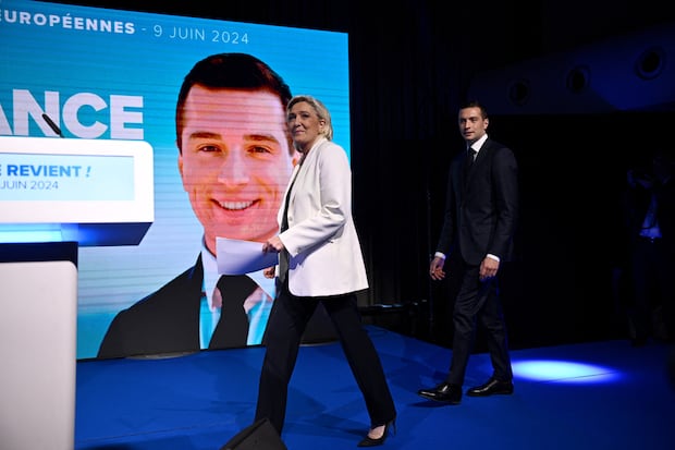 French far-right National Rally (RN) party leader Marine Le Pen and party leader Jordan Bartella take to the stage to address campaigners after European elections.  (Photo by Julian de Rosa / AFP).