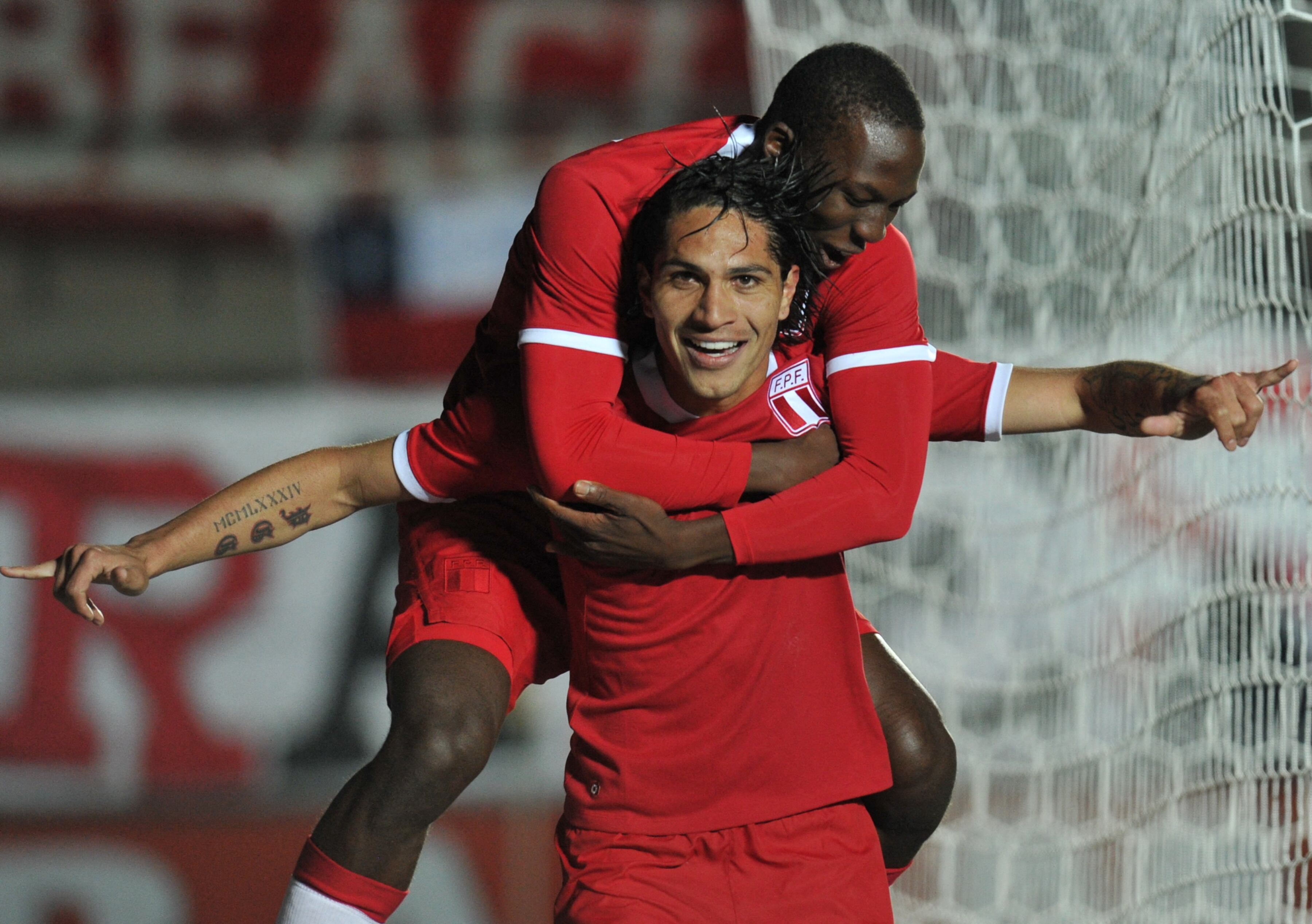 Peruvian forward Paolo Guerrero celebrates with forward Luis Advincula (back) after opening the score against Uruguay during their 2011 Copa America Group C first round football match, at the Estadio del Bicentenario stadium in San Juan, 1126 Km west of Buenos Aires, on July 4, 2011. AFP PHOTO / RODRIGO ARANGUA (Photo by RODRIGO ARANGUA / AFP)