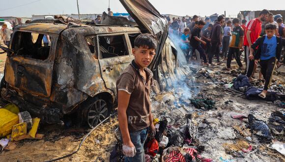 Palestinos se reúnen en el lugar de un ataque israelí en un área de campamento que alberga a desplazados internos en Rafah el 27 de mayo de 2024, en medio de batallas en curso entre Israel y el grupo militante palestino Hamas. (Foto de Eyad BABA / AFP)
