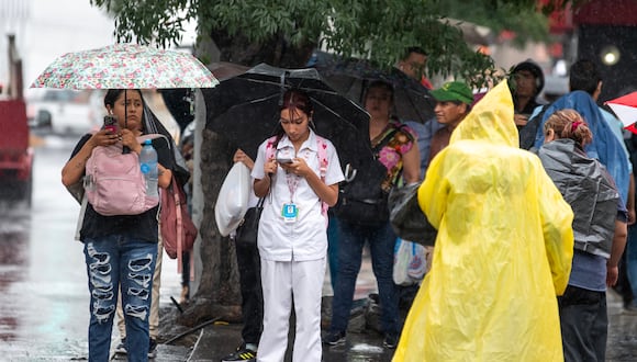 Ciudadanos caminan con paraguas e impermeables bajo una lluvia, en la ciudad de Monterrey, México, el 19 de junio de 2024. (Foto de Miguel Sierra / EFE)