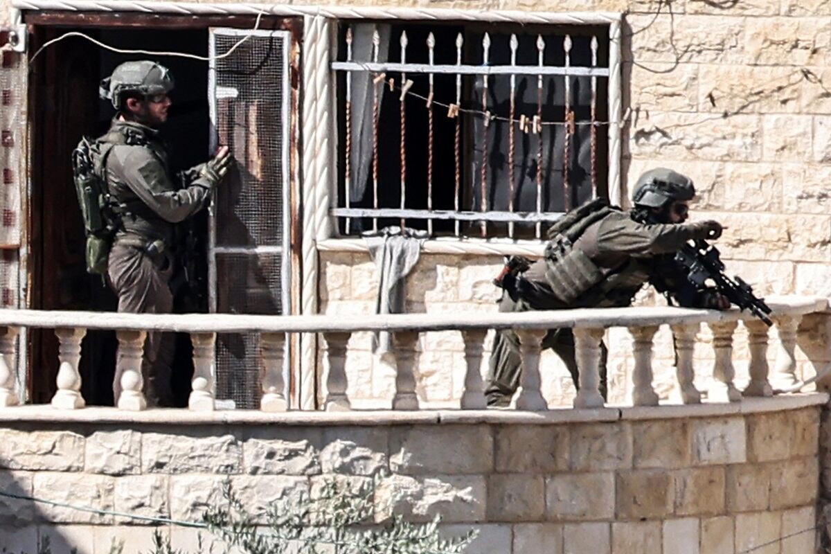 Soldados del ejército israelí toman posición en el balcón de un edificio durante una redada del ejército en Qabatiyah, al sur de Jenin, en la Cisjordania ocupada, el 19 de septiembre de 2024. (Foto de Zain JAAFAR / AFP)