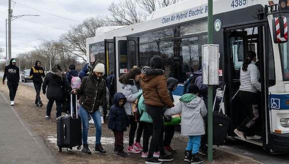 Migrantes recién llegados suben a un autobús frente al refugio Floyd Bennett Field, el 21 de febrero de 2024, en el distrito de Brooklyn de Nueva York. (Foto de ANGELA WEISS / AFP)